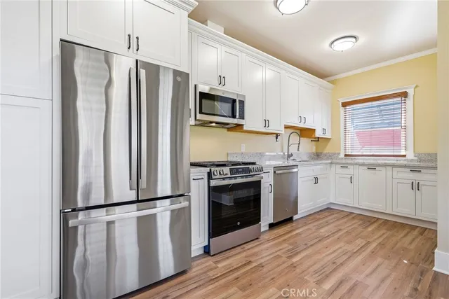 a kitchen with stainless steel appliances a refrigerator sink and microwave