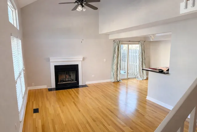a view of an empty room with a fireplace and a window