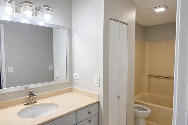 a bathroom with a granite countertop sink toilet and shower