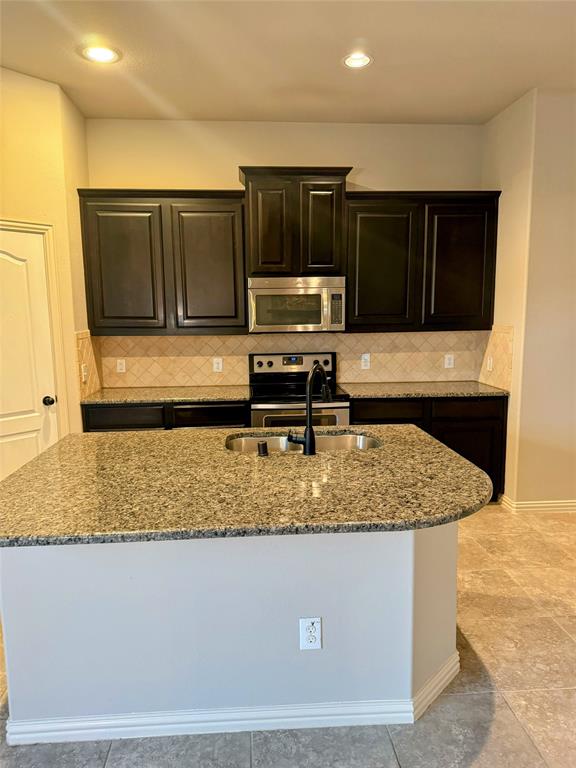 236 Archer Way Forney, TX 75126 - Photo 8 of 35 a kitchen with kitchen island a sink a stove and a refrigerator