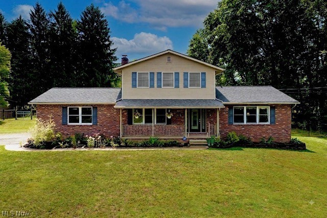 3090 Sourek Road Akron, OH 44333 - Photo 2 of 36 Two-story residence featuring a brick and siding exterior, front porch with railing, and landscaping