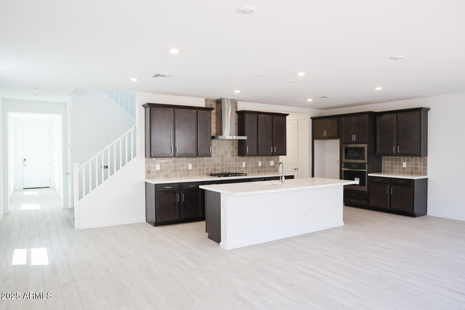 2460 West Rowel Road Phoenix, AZ 85085 - Photo 2 of 25 a large white kitchen with kitchen island granite countertop a stove top oven a sink a counter space and cabinets