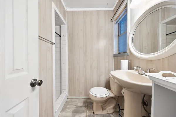 a view of an empty room with wooden floor and a ceiling fan