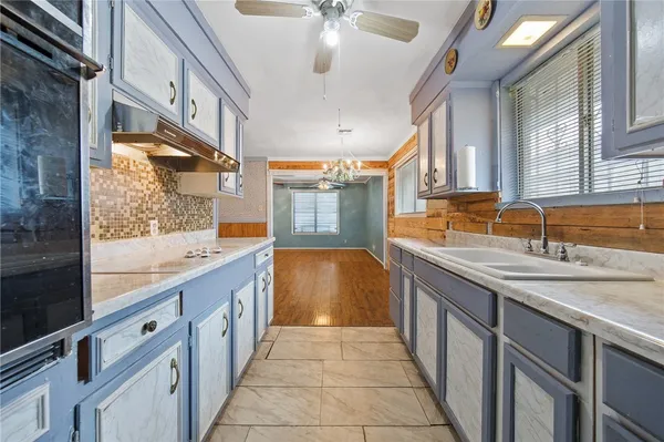 a bathroom with a granite countertop sink a toilet a mirror and bathtub