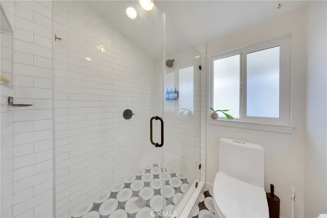 a bathroom with a granite countertop toilet and a shower