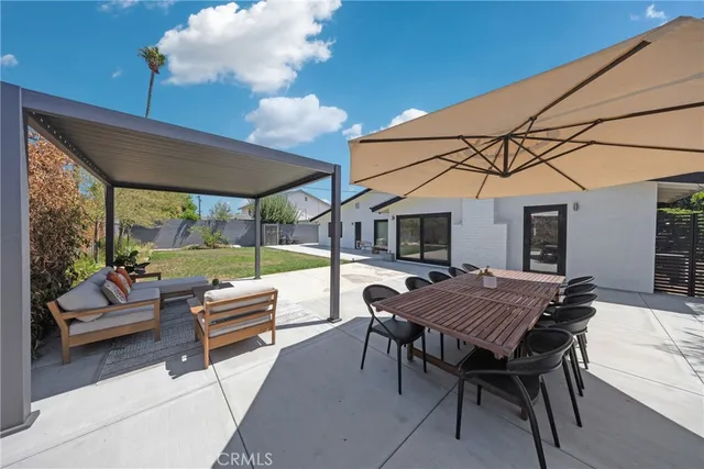 a patio with a table and chairs and potted plants