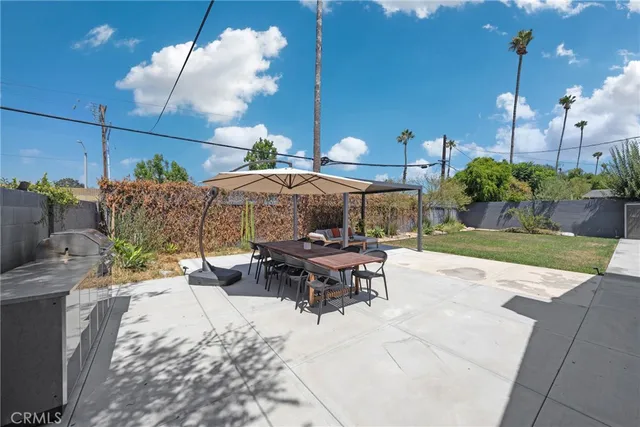 a view of a patio with table and chairs potted plants