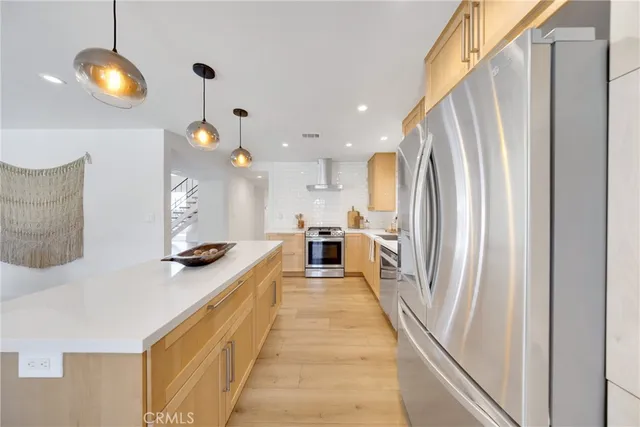 a kitchen with stainless steel appliances a refrigerator and a stove