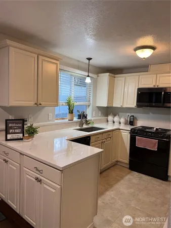 a kitchen with kitchen island granite countertop a sink cabinets and stainless steel appliances