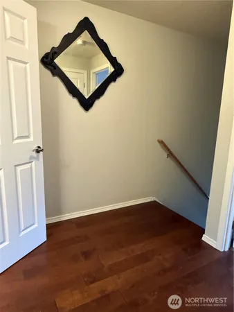 an empty room with wooden floor and cabinet