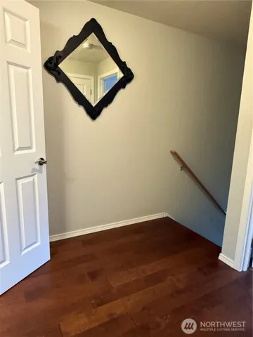 an empty room with wooden floor and cabinet