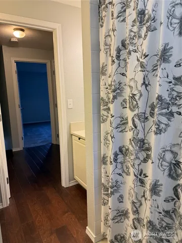 a view of a hallway with wooden floor and stairs