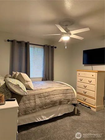 a bedroom with a bed and a flat tv screen