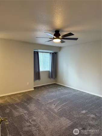 a view of an empty room with a chandelier fan