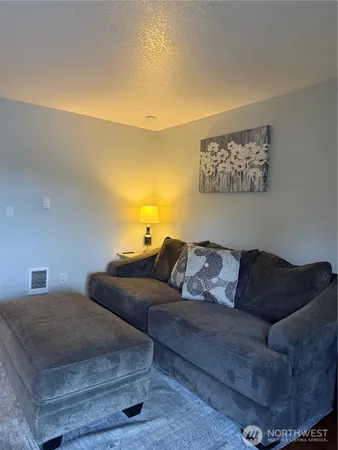 a living room with couches and kitchen view
