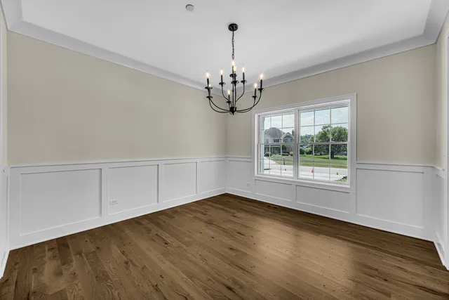 a view of wooden floor chandelier and windows in a room