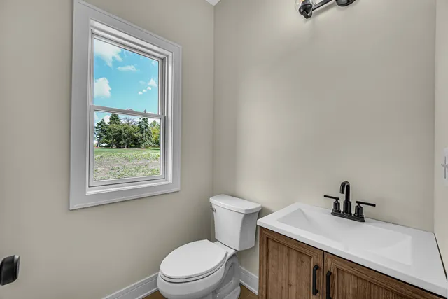 a bathroom with a sink a toilet and a window