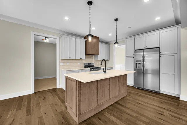 a kitchen with kitchen island a sink and a refrigerator