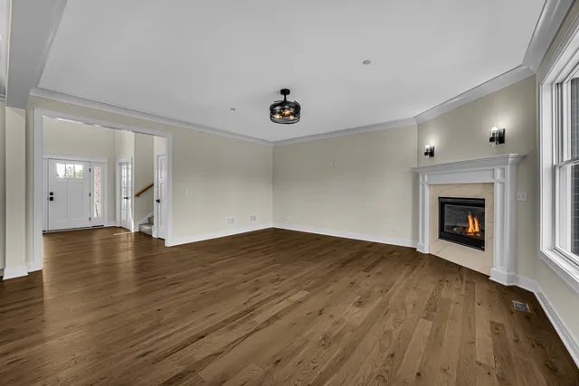 an empty room with wooden floor and a fireplace