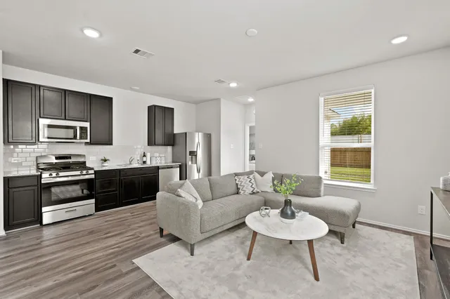 a living room with furniture flat screen tv and window