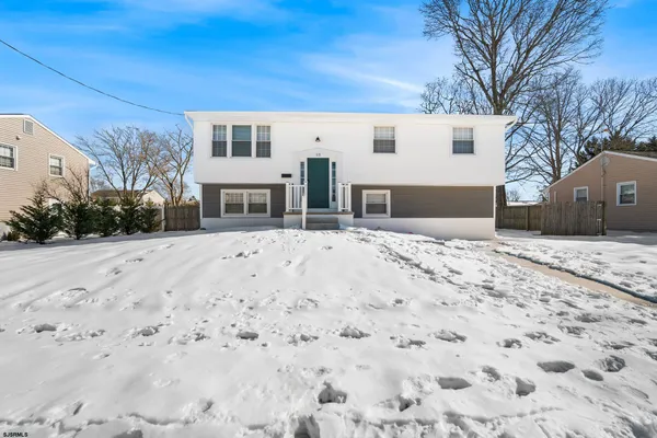 a view of house with a yard covered in snow
