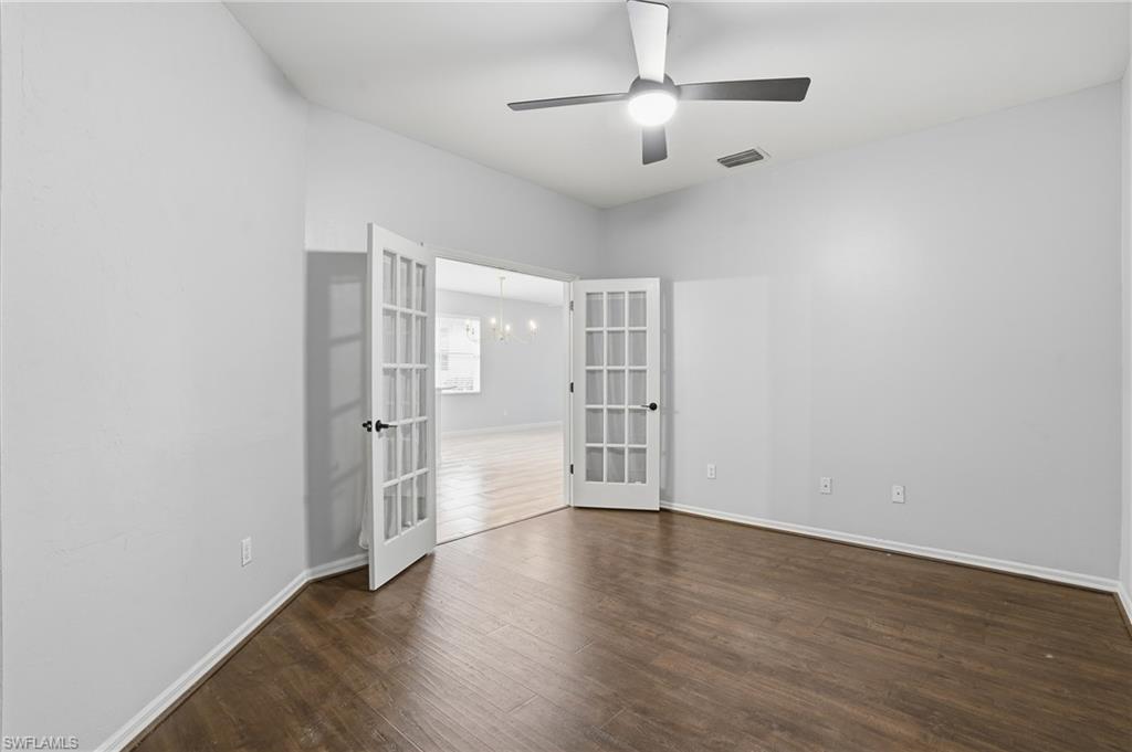 12517 Stone Valley Loop Fort Myers, FL 33913 - Photo 19 of 36 an empty room with wooden floor chandelier fan and windows