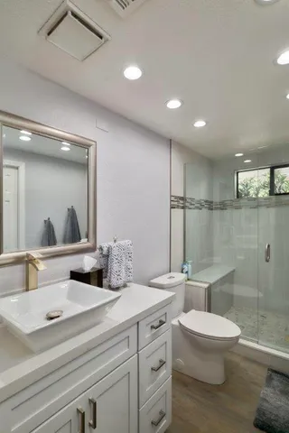 a bathroom with a double vanity sink toilet and a mirror