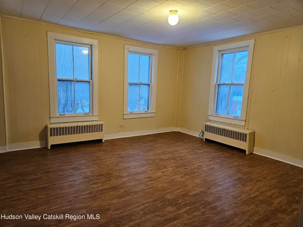 a view of room with wooden floor and cabinet