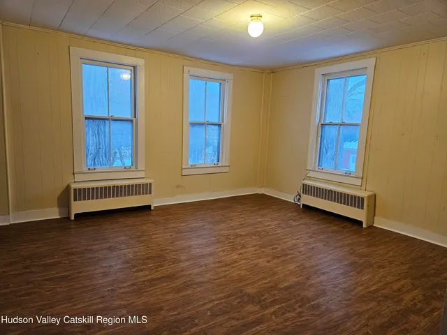 a view of room with wooden floor and cabinet