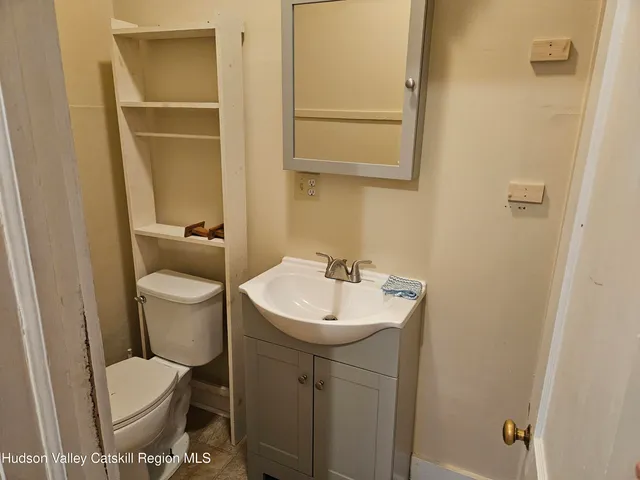 a bathroom with a toilet sink and mirror