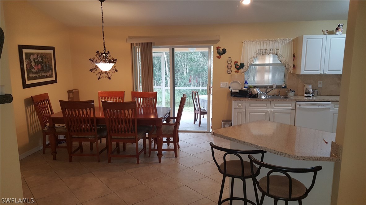 9041 Buckingham Road Fort Myers, FL 33905 - Photo 5 of 11 a dining room with furniture a chandelier and window