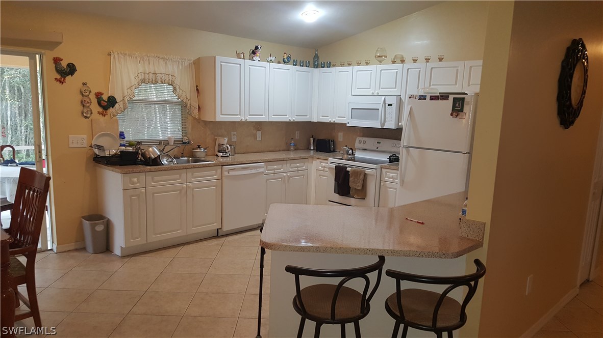 9041 Buckingham Road Fort Myers, FL 33905 - Photo 6 of 11 a kitchen with a sink appliances and cabinets