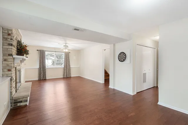 a view of a livingroom with wooden floor and a ceiling fan