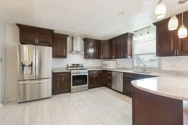 a kitchen with stainless steel appliances granite countertop a refrigerator stove top oven and sink