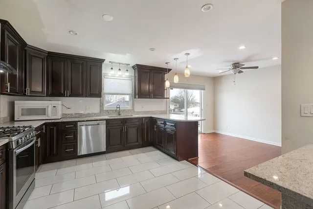 a large kitchen with granite countertop a stove a sink dishwasher and a oven