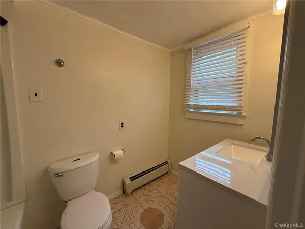 a bathroom with a sink a toilet and a window