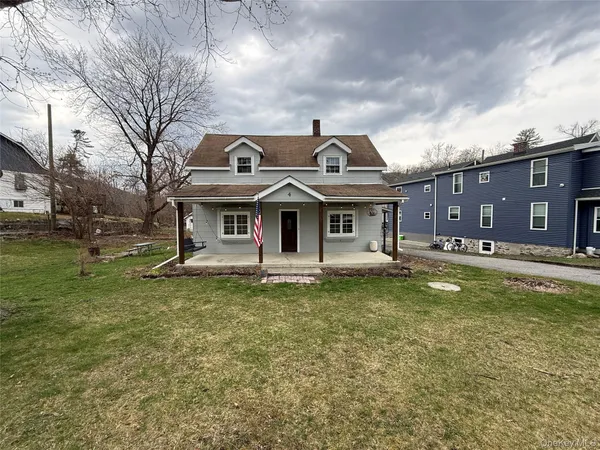 a view of a big house with a big yard and large trees