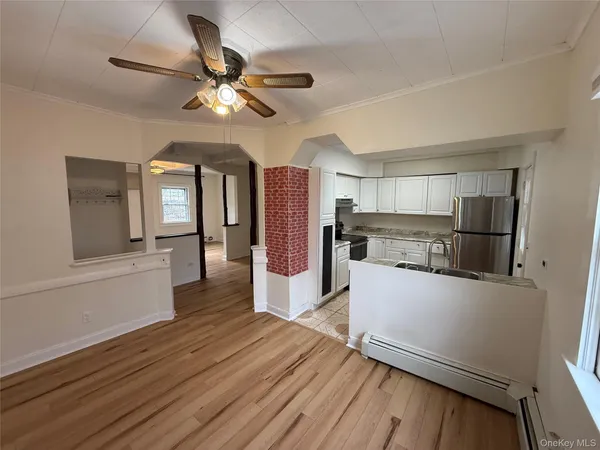 a kitchen with stainless steel appliances wooden floor and a refrigerator