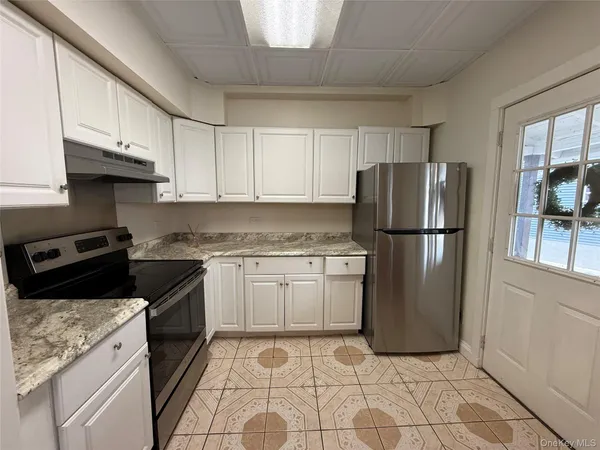 a kitchen with a refrigerator sink and cabinets