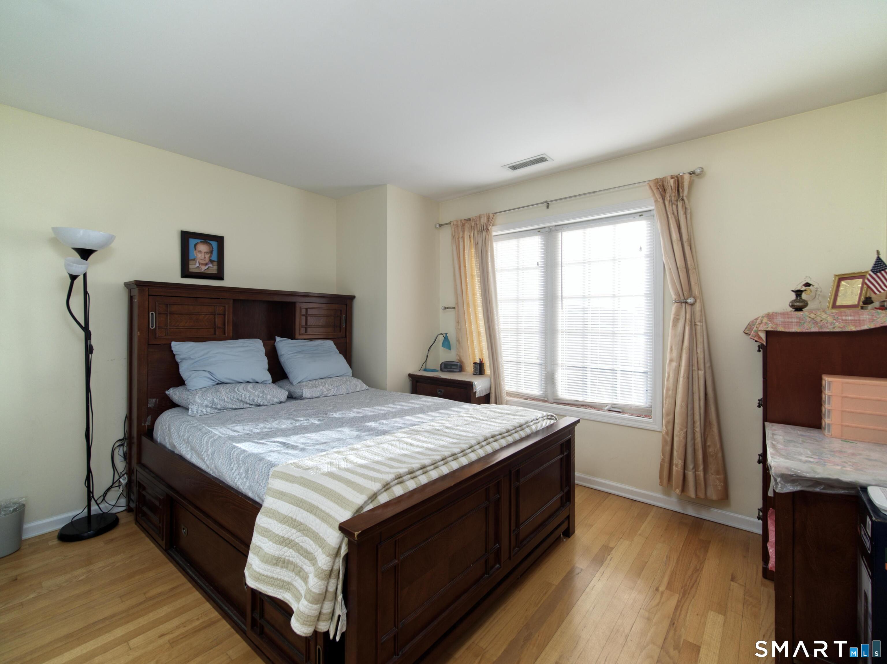 65 Benton Street, Unit 65 Fairfield, CT 06825 - Photo 15 of 35 a bed sitting in a bedroom next to a window