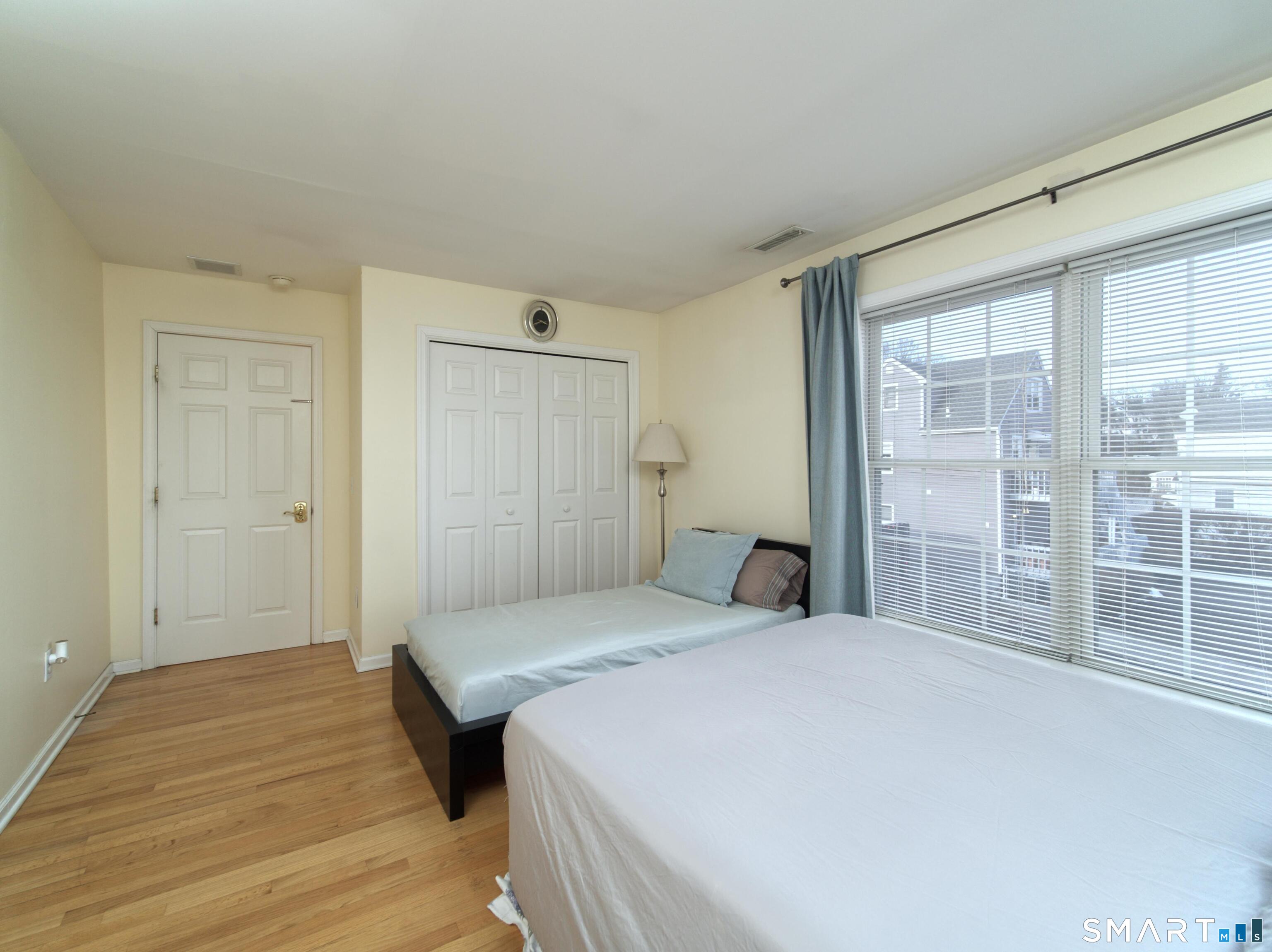 65 Benton Street, Unit 65 Fairfield, CT 06825 - Photo 17 of 35 a bedroom with a large bed and a large window