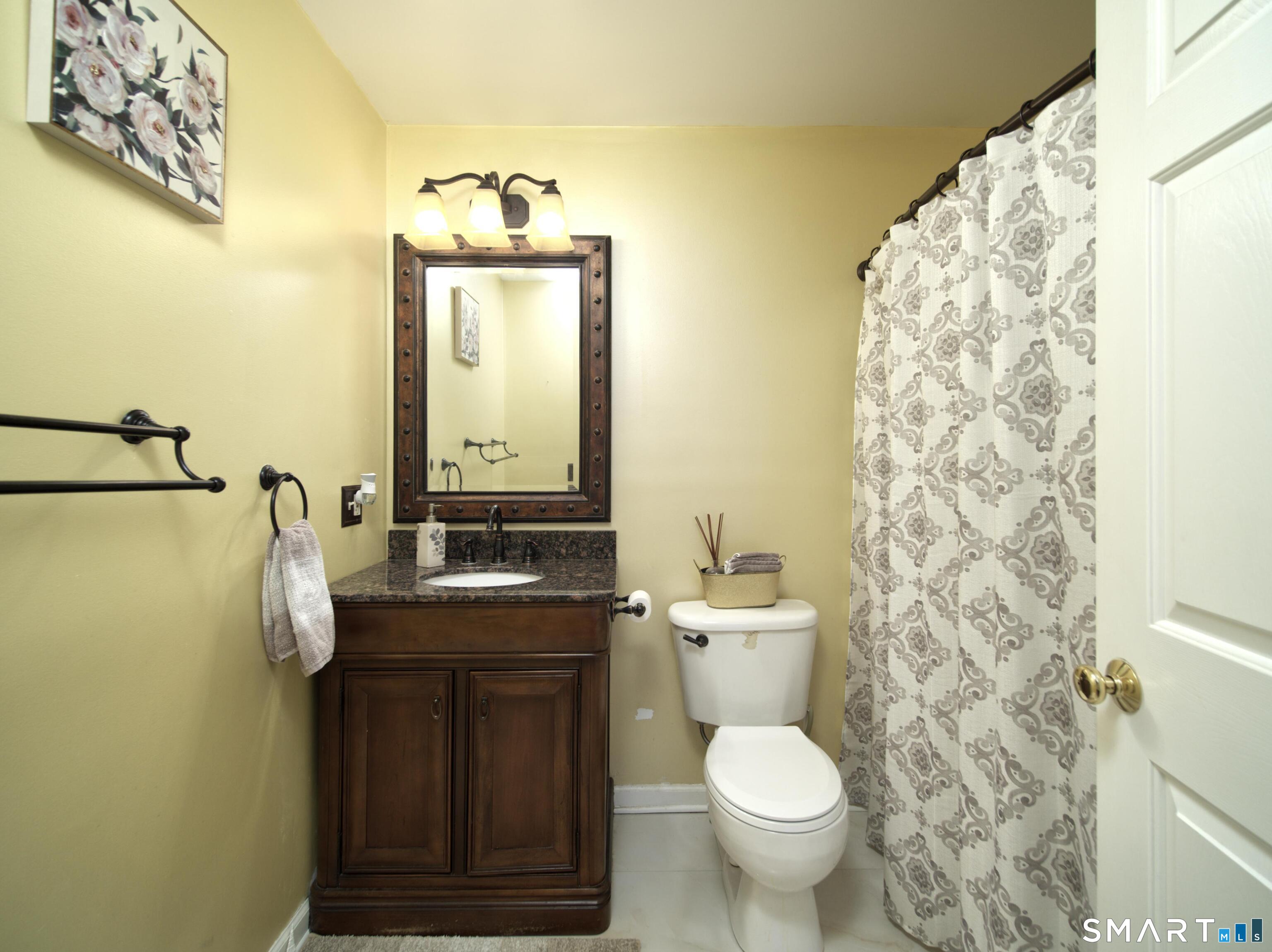 65 Benton Street, Unit 65 Fairfield, CT 06825 - Photo 19 of 35 a bathroom with a granite countertop toilet sink and mirror