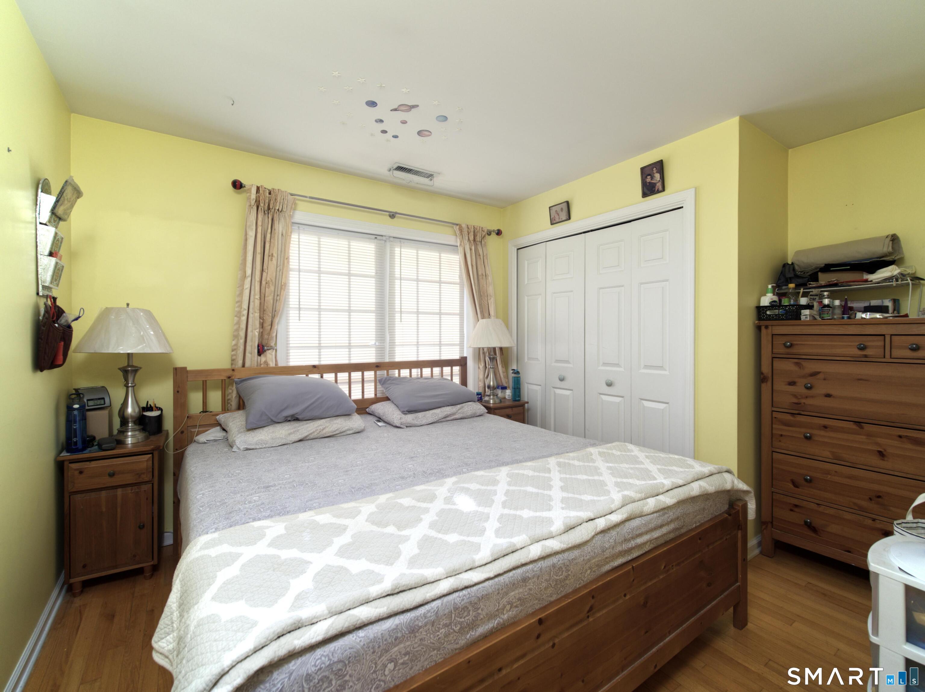 65 Benton Street, Unit 65 Fairfield, CT 06825 - Photo 20 of 35 a bedroom with a bed and wooden floor