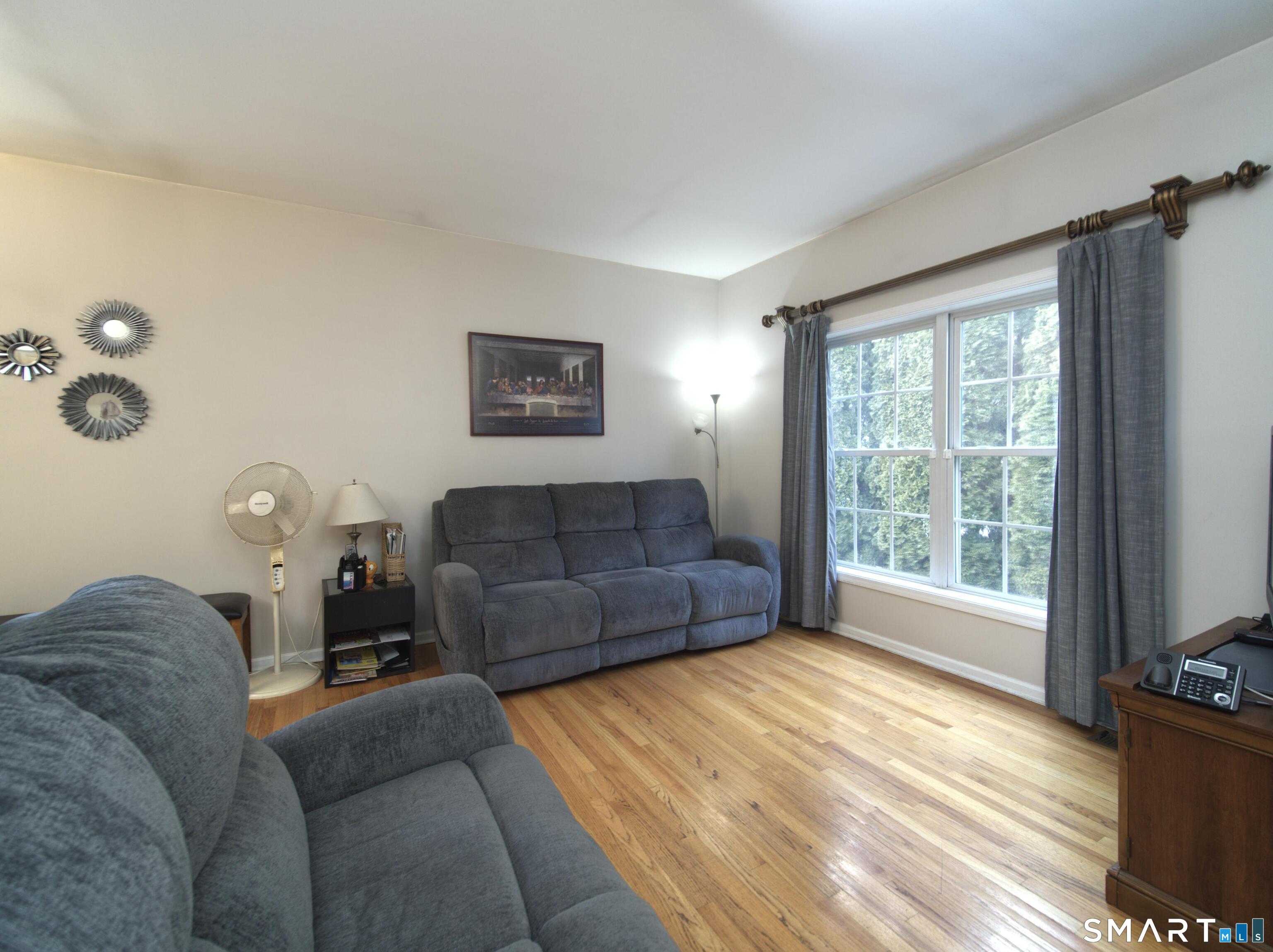 65 Benton Street, Unit 65 Fairfield, CT 06825 - Photo 5 of 35 a living room with furniture and a flat screen tv