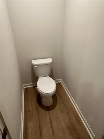 a white toilet sitting next to a white wall