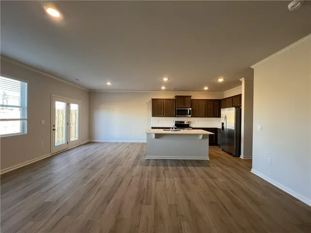 a large kitchen with kitchen island a sink wooden floor and stainless steel appliances