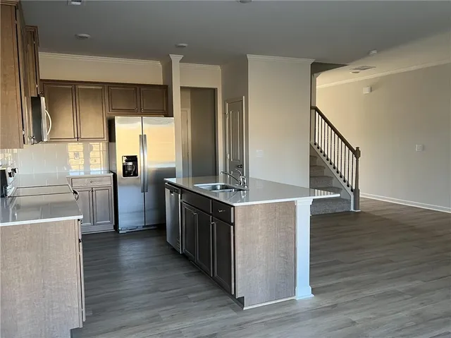 a kitchen with stainless steel appliances granite countertop a stove a sink and a refrigerator