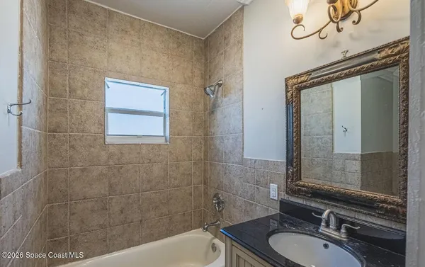 a bathroom with a granite countertop sink a mirror and a bathtub