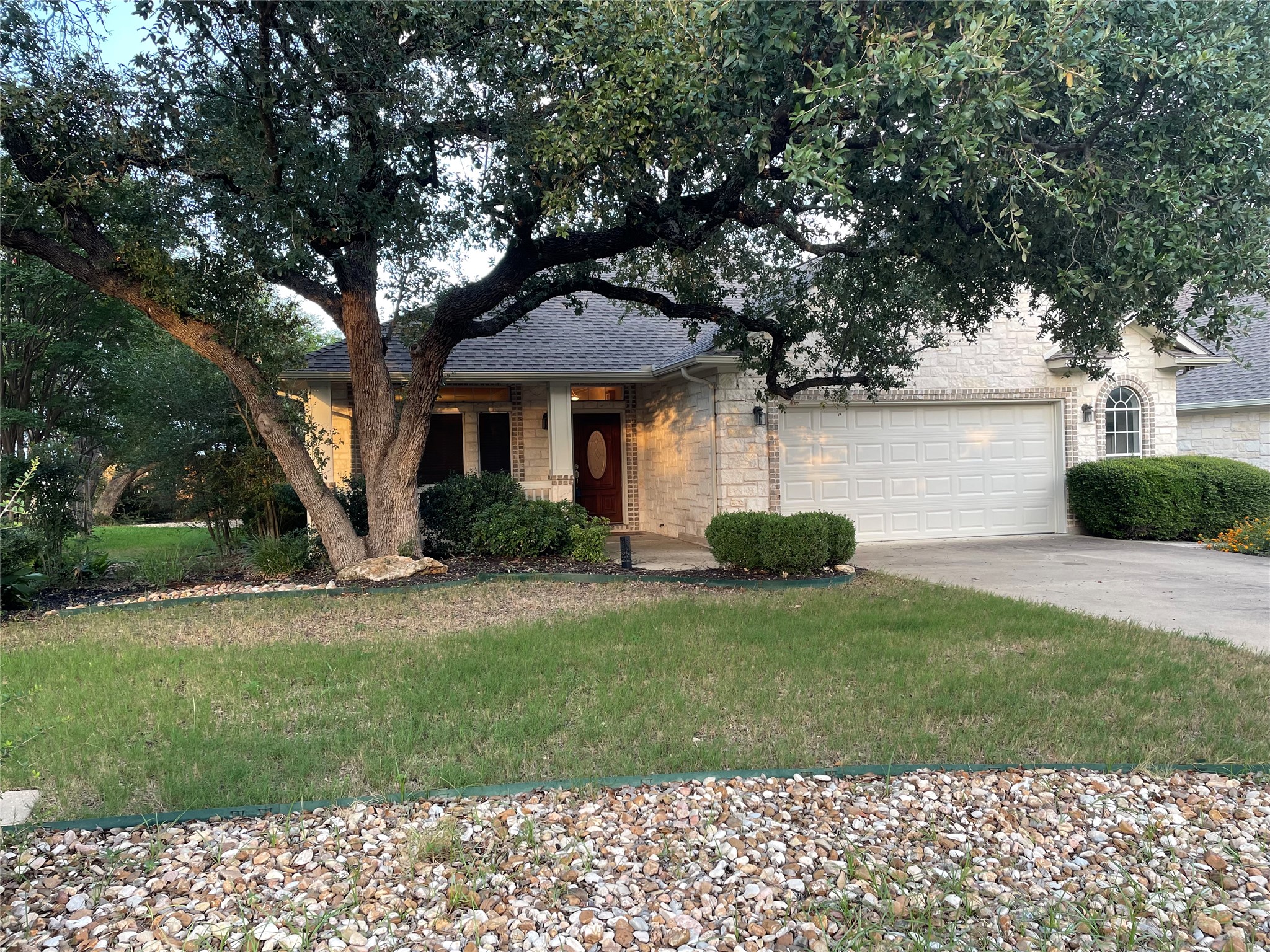 120 Brazos Drive Georgetown, TX 78628 - Photo 1 of 33 View of front of home with stone siding, a front yard, concrete driveway, and an attached garage