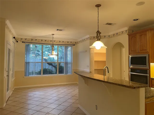 a view of a kitchen with a sink wooden floor and a chandelier